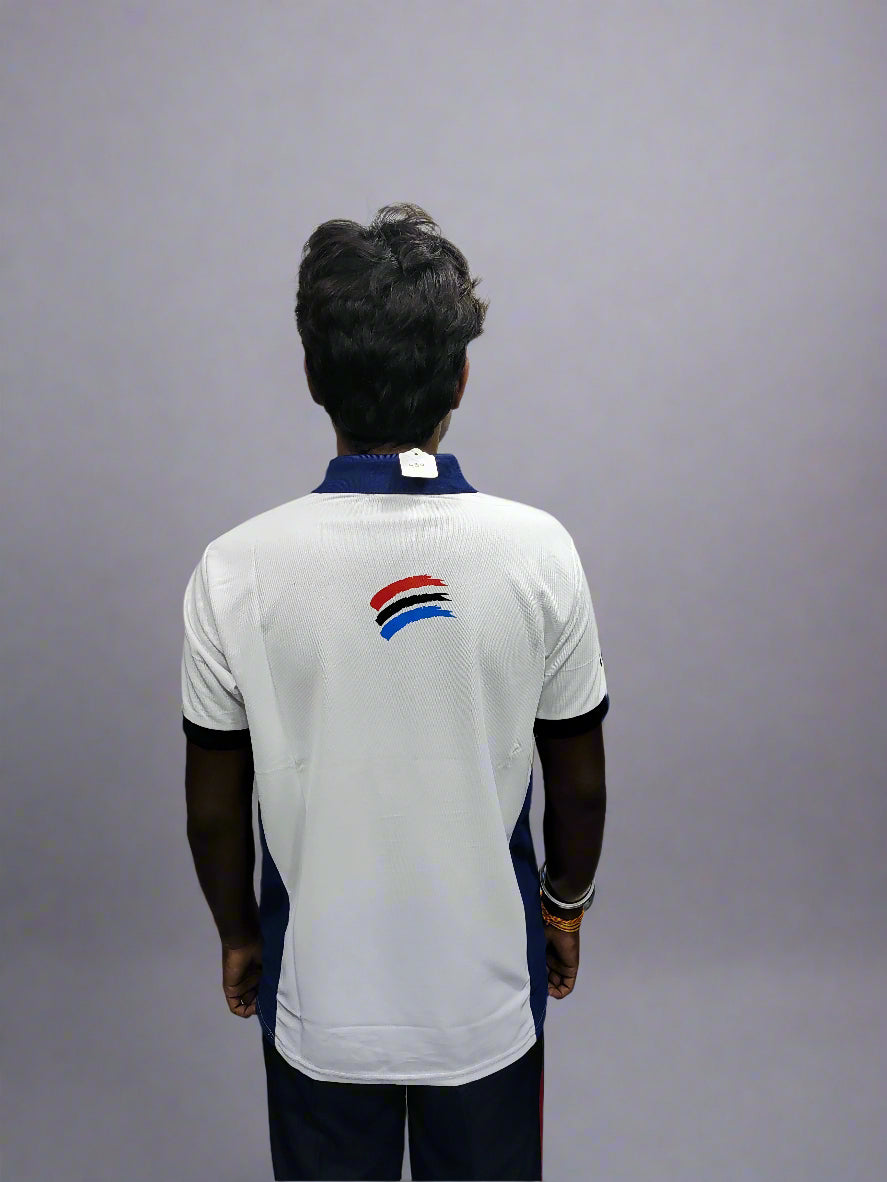 Person wearing a white sports jersey with a logo on the back against a gray background