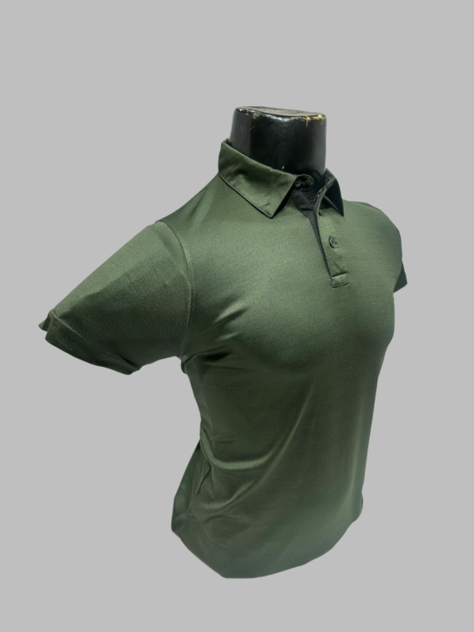 Green polo shirt on a mannequin bust against a white background