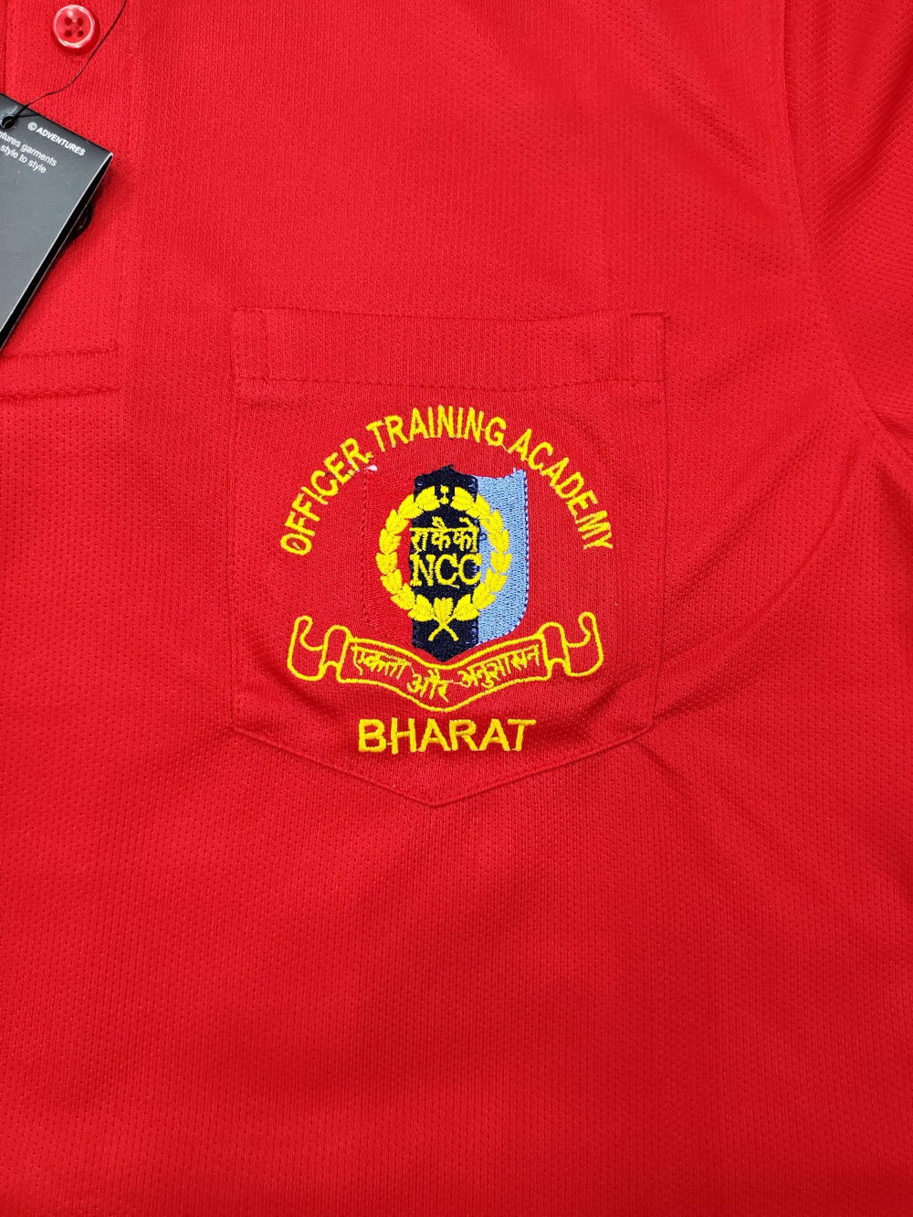 Red shirt with an embroidered logo on a red background