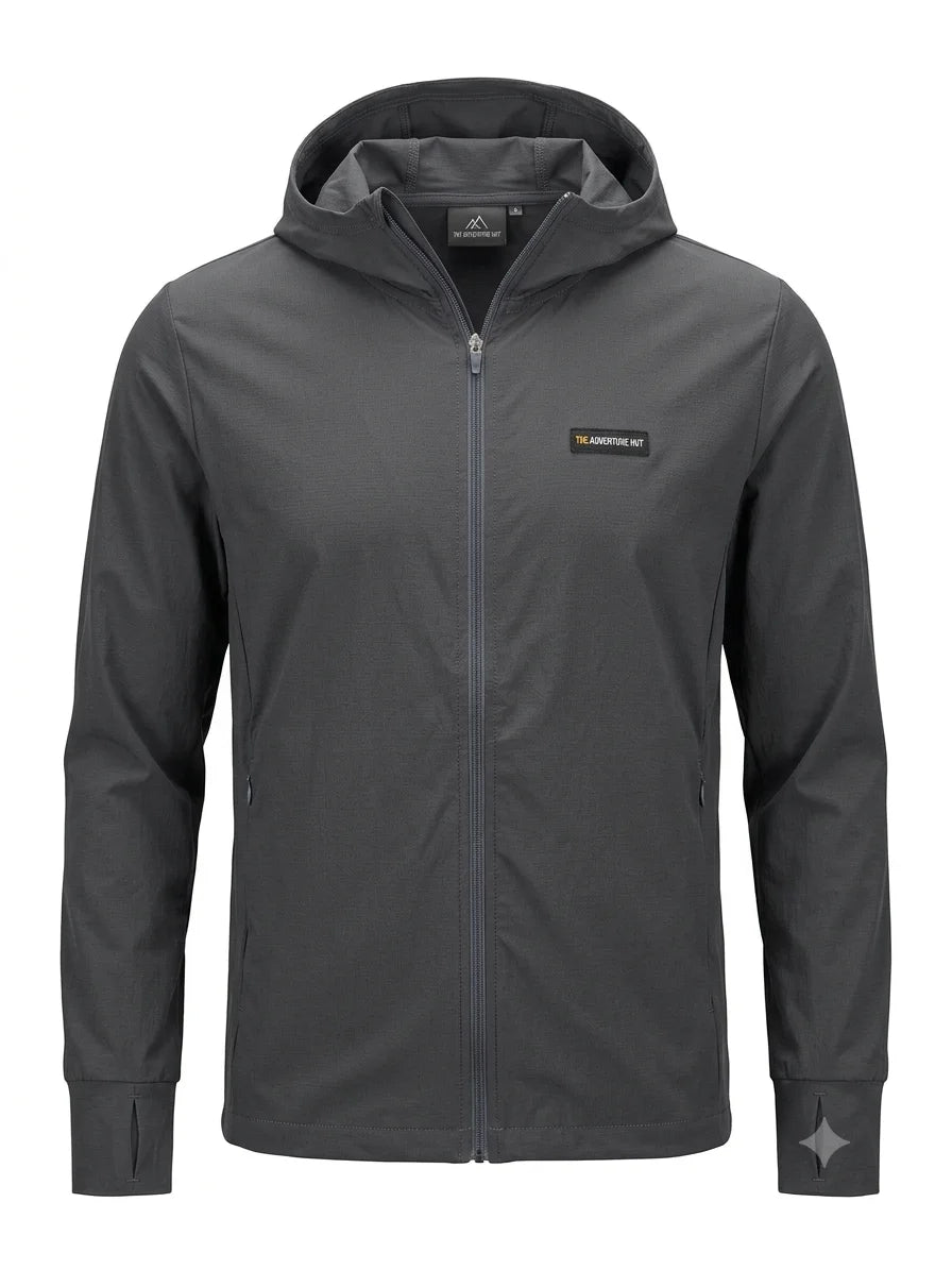 A dark gray hooded zip-up jacket with a small yellow and black 'The Adventure Kit' logo on the left chest, displayed on a clean white background.