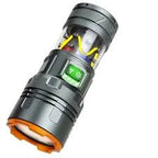 Close-up of a flashlight with a green light on a gray background